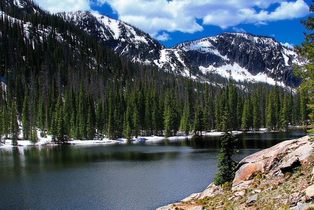 Maroon Bells reflected in Maroon Lake with Crater Lake trail in foreground